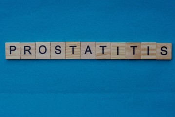 gray word prostatitis from small wooden letters on a blue table