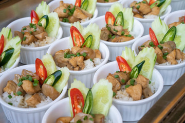 Little and small local food chicken with sauce over rice and decorated with spring onion and red - green chilli on top of it for outdoor event.