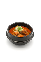 Isolated Kimchi soup in the black stone bowl in studio light on the white background.