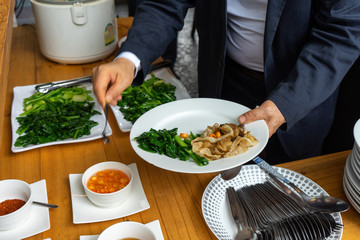 business man in business suit preparing the Fried noodle with pork and broccoli for lunch.
