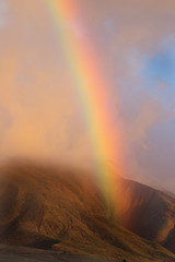 Rainbow over West Maui mountains at sunset.