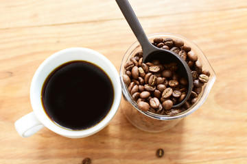 coffee beans, accompanied by cup of hot coffee