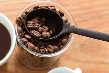 coffee beans, accompanied by cup of hot coffee