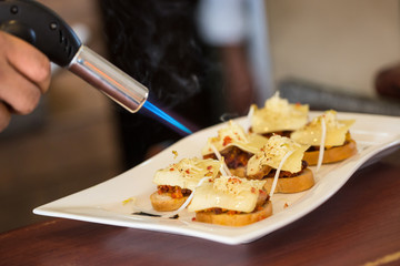 A cheff burner torch over snacks
