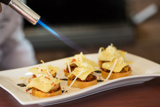 A cheff burner torch over snacks