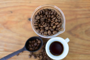 coffee beans, accompanied by cup of hot coffee