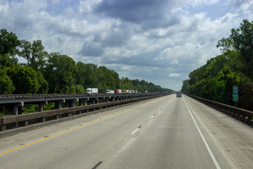 The road, a long bridge on which cars ride on a sunny summer day. Summer on the roads of Louisiana, USA