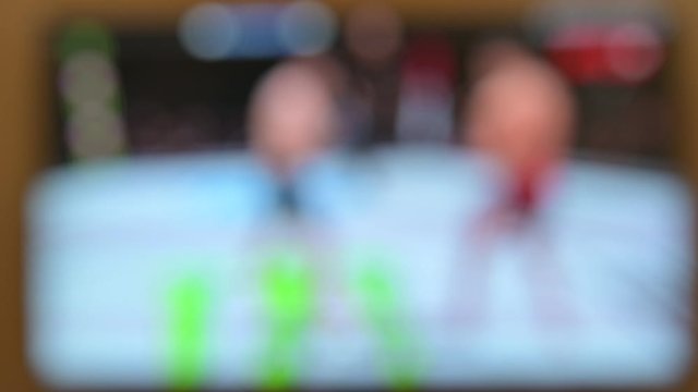 Watch TV. Close-up of a man watching and turning off the television, television ponel on the background. Interactive tv
