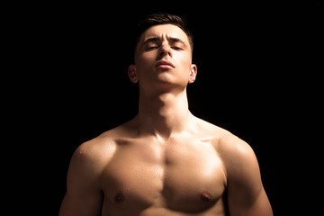 Fototapeta premium Handsome wet sport sexy stripped guy portrait with waterdrops and smoke on isolated black background