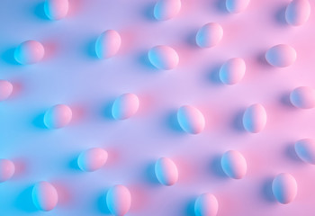 Chicken eggs lit with colorful blue and pink neon lights abstract background pattern