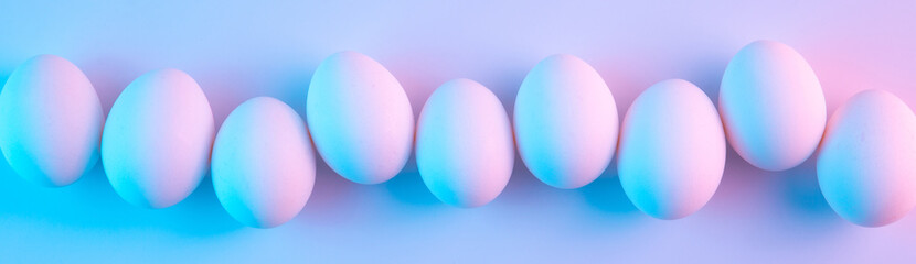 Obraz na płótnie Canvas Holographic futuristic chicken eggs lit with blue and pink neon lights