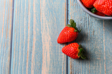 Juicy beautiful organic strawberries on a blue background.