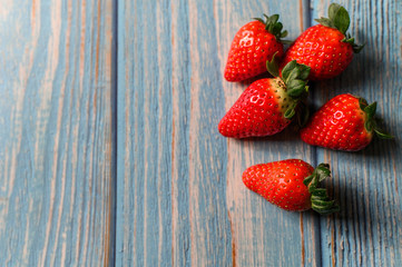 Juicy beautiful organic strawberries on a blue background.