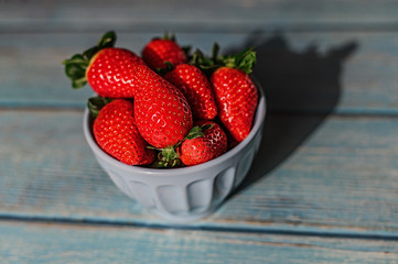 Juicy beautiful organic strawberries on a blue background.