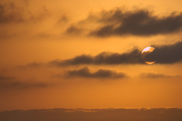 The sun rising over a sea of clouds leaves the sky in orange colors