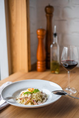 Spaghetti carbonara with pancetta, eggs and cheese in white bowl on the wooden table