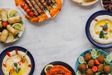 Lebanese food eaten for Ramadan eid with space for text. Middle eastern traditional cuisine including falafel, hummus, halal kebab meat, dates, Muajjanat Sabanej,  muhammara and mutabal. 