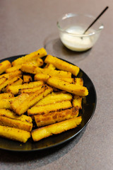 homemade vegan poelnta chips made with oat milk and cornmeal with vegan aioli sauce to the side