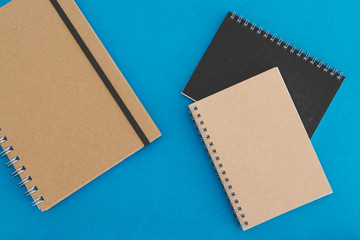 group of minimalist looking notebooks of different shapes on blue