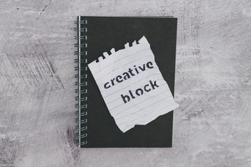 scrunched paper with Creative Block text on desk with notepad, lack of inspiration
