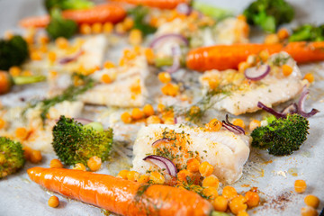 carrots, broccoli, chickpeas, fish fillets, onions and spices baked in the oven