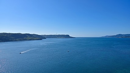 平戸大橋から見た紺碧の海を疾走する漁船と漁をする漁船＠長崎