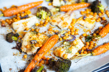carrots, broccoli, chickpeas, fish fillets, onions and spices baked in the oven