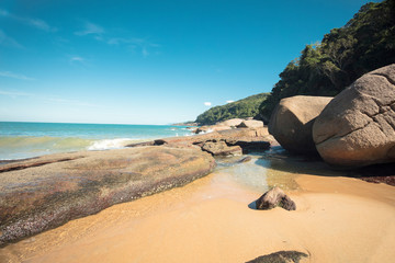 Beautiful Parnaioca beach with crystal blue water and stones, deserted tropical beach on the sunny coast of Rio de Janeiro, Ilha Grande in the city of Agnra dos Reis, Brazil