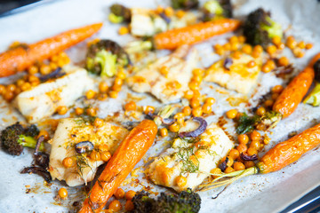 carrots, broccoli, chickpeas, fish fillets, onions and spices baked in the oven