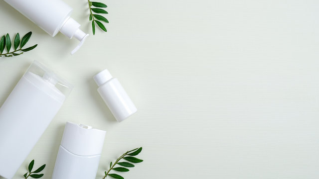 Natural organic SPA cosmetic products set with green leaves. Top view herbal skincare beauty products on green background. Banner mockup for eco shop or beauty salon. Flat lay minimalist style