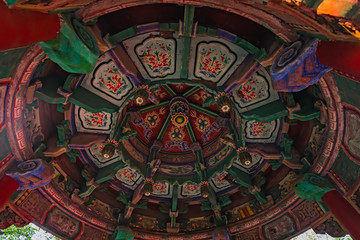 Colorful paintings on the ceiling of an altar of Buddhist temple