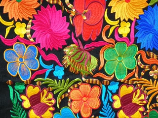 Zelfklevend Fotobehang  Close up of сolorful embroidered decorative textile and pillows from Otavalo city at the artisans market © Iryna