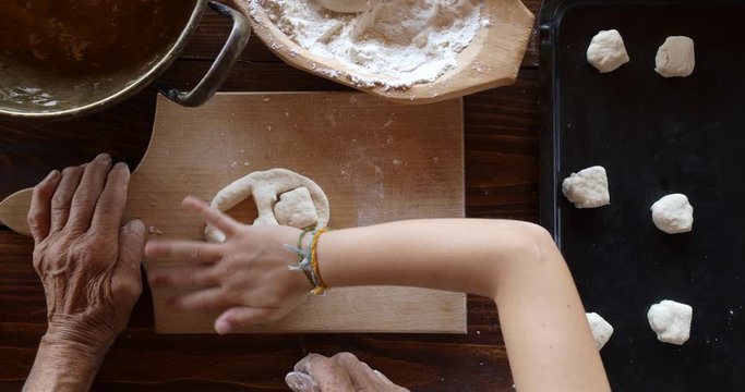 Top view preparing food. Cooking With Grandma. Beautiful Little Girl Learns How To Make Cookies.