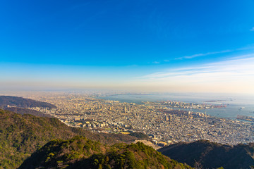 Kobe city panoramic view from Mt. Maya Kikusedai park observatory platform in sunny day sunset time with blue sky background, famous by the 10 ten million dollar night views. Hyogo Prefecture, Japan