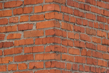 Obraz premium Brick wall texture. View of the brickwork from the corner of the building. Red background. Cement bonded building material. Part of the design.