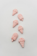 Mini ice cream shape bath bomb with flaky red color isolated on white background.