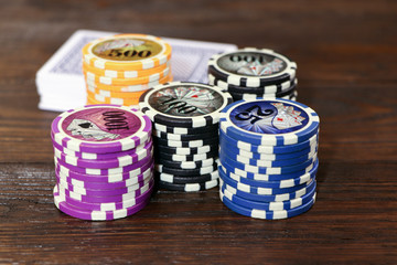 Playing cards and poker chips on a wooden table. Stack of chips for poker.