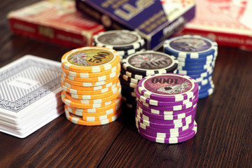 Playing cards and poker chips on a wooden table. Stack of chips for poker.