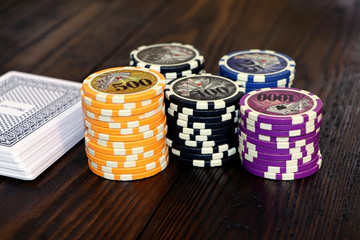 Playing cards and poker chips on a wooden table. Stack of chips for poker.