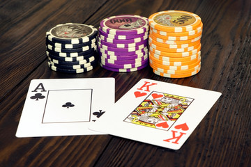 Playing cards and poker chips on a wooden table. Stack of chips for poker.