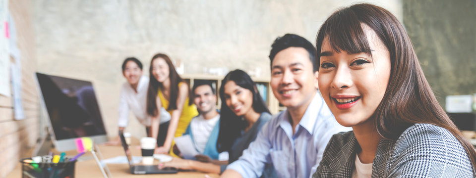 Banner Of Happy Creative Team Are Smiling And Looking At Camera In Modern Workspace Office. Happy Group Of Confident Employee In Cowork. Relation And Engagement Concept.