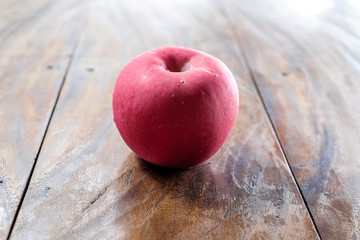 Fresh red apples fruit put on the old wooden floor in room which has  light