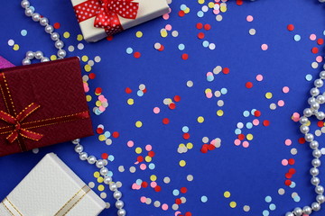 Gift boxes surrounded by necklaces and confetti