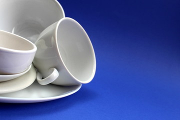 White dishes are stacked on a blue background