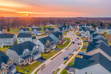 Aerial sunset panorama of luxury real estate development single family house neighborhood curving...