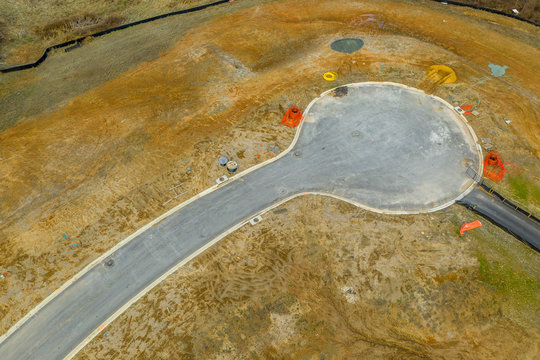 Aerial view of a paved cul-de-sac at a new construction site before any houses are built around it