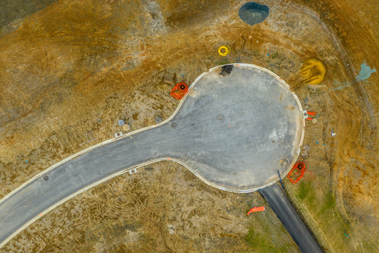 Aerial view of a paved dead end at a new construction site before any houses are built around it