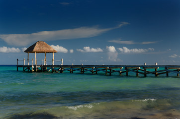 Evening light on a thatched roof gazebo on the end of a dock on the Mayan Riviera