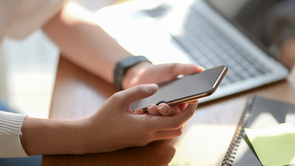 Cropped shot of college girl looking for an idea from smartphone for her project
