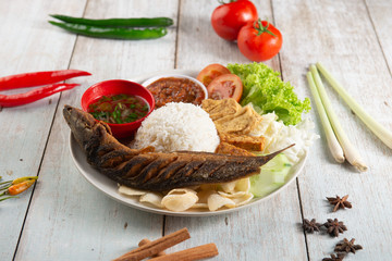 fried catfish with rice , sambal , vegables and mixed dish